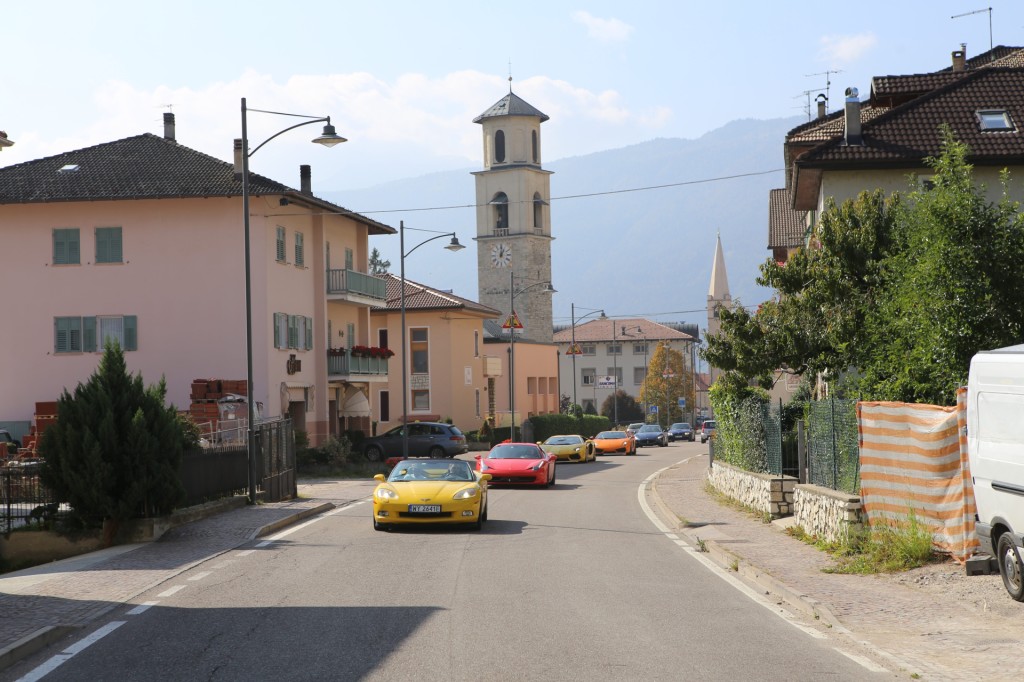 Klimat włoskich alpejskich miasteczek różni się od tych, które kilkaset kilometrów temu odwiedzaliśmy pokonując Tyrol. Drewniane okiennice, pastelowe kolory przełamywane gdzieniegdzie jaskrawymi elementami elewacji. Na zewnątrz życie płynie spokojnie, choć w domach, jak na włoskich górali przystało,  